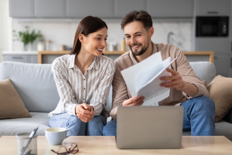 happy couple reviewing documents at home